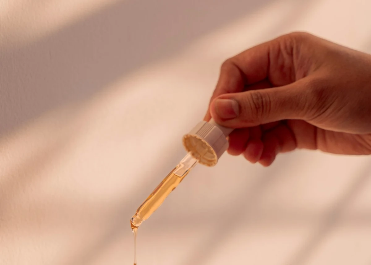 Editorial hand and pipette detail; not a specific product
